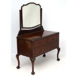 An early 20thC mahogany dressing table with shaped bevelled mirror.
