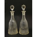 A pair of early 20thC cut glass decanters with etched floral and bird decoration.