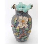 A large ceramic vase decorated with grey textured gravel finish and having relief moulded flowers