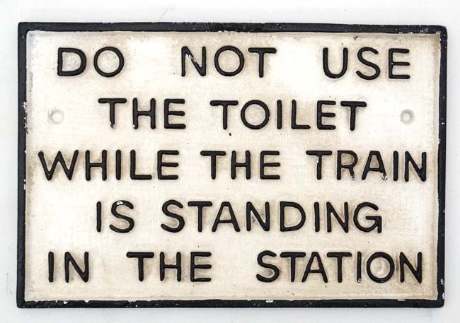 A 21stC painted cast metal sign "Do not use toilet whilst train in station".