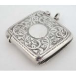 A silver vesta case of shaped form and acanthus scroll decoration.