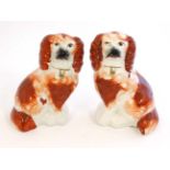 A pair of Victorian iron red and white Staffordshire Spaniel Dogs, facing left and right,