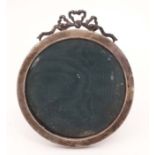 A Victorian silver photograph frame with ribbon cresting to top and green velvet easel back.