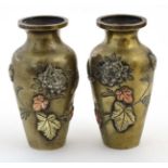 A pair of Japanese brass baluster shaped vases with inlaid copper and silver depicting flowers