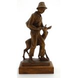 A c.1900 Swiss carved wooden figure group of a young boy feeding a deer.