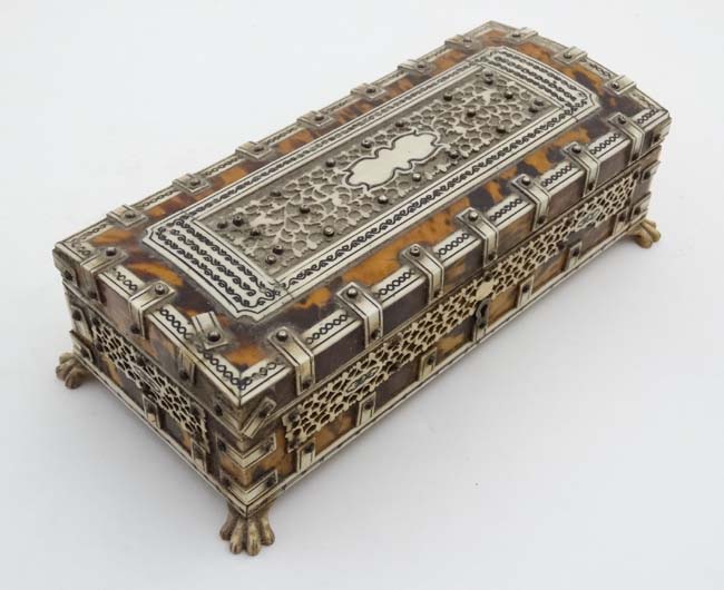 A 19thC Tortoiseshell and ivory table casket standing on four hairy lions paw feet and opening to
