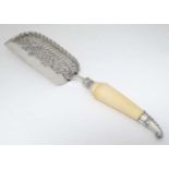 A silver plated crumb scoop with silver mounted ivory handle with silver collar.