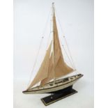 A 20thC wooden hulled Pond yacht on stand , painted in cream with single mast and wooden keel.