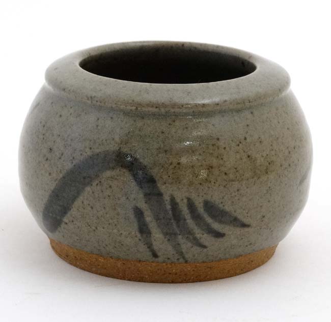 A signed studio pottery pot decorated with black marks on a grey/green ground ,