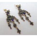 A pair of yellow metal and 9ct gold drop earrings set with a profusion of amethysts and peridot.