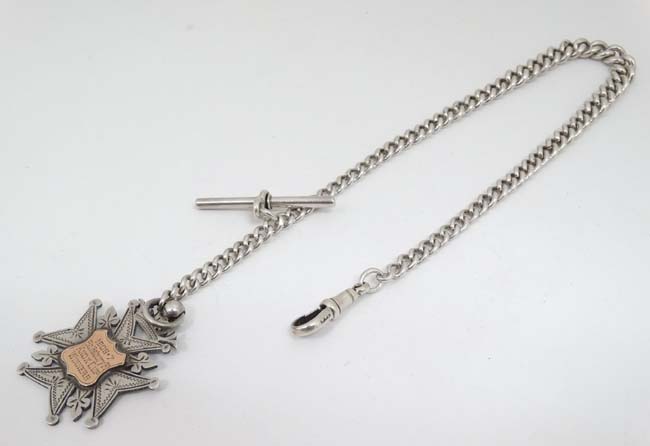 A silver albert watch chain of graduated curblink form with silver fob engraved 1906-7 Salisbury