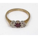 A 9ct gold ring set with central ruby flanked by 2 diamonds.