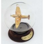 Militaria : A model Supermarine Spitfire within a glass ball and standing on a circular plinth ,