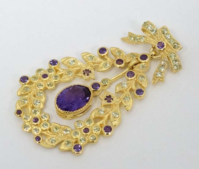A silver gilt pendant set with amethysts and peridot. Marked 'Sterling' .