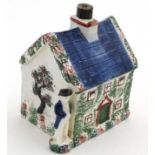 A late 19thC Staffordshire Cottage money box, decorated in blue,
