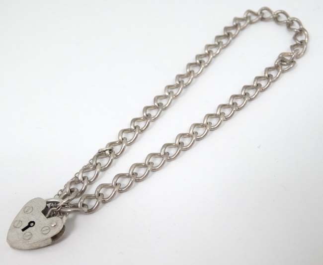 A silver bracelet with padlock clasp hallmarked London 1984 maker ASJ.