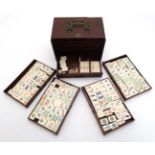 A c1920s Mah-Jongg set of bamboo and bone construction in fitted case of Chinese hard wood and