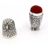 A novelty white metal needle case formed as an owl, opening to reveal pin/needle cushion within.