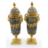 A 21stC pair of Victorian style marble and ormolu lidded urns with bacchanalian style decoration.