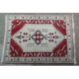 Rug / Carpet : a hand made woollen rug in reds, creams and black,