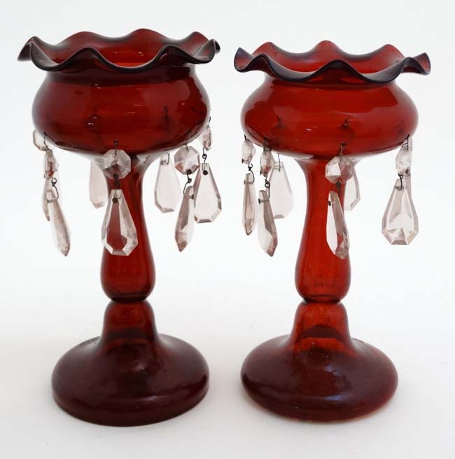A pair of late 19thC / early 20thC ruby glass pedestal table lustres with clear glass lustre drops