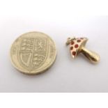 A 14ct (585) gold pendant / charm formed as a toadstool with red enamel decoration.