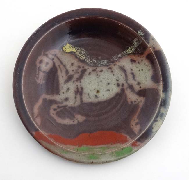 A large Studio pottery charger decorated to centre with the image of a rearing horse with