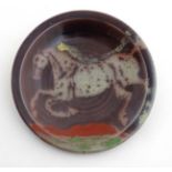 A large Studio pottery charger decorated to centre with the image of a rearing horse with