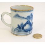 A small Oriental Blue and white coffee can decorated with an Oriental landscape and having gilt rim.