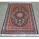 Carpet / Rug : A machine made Keshan carpet, the blue and red ground with stylised floral motiffs.