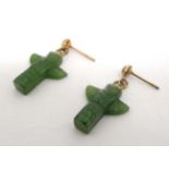 A pair of gilt metal drop earrings set with carved jade drops formed as Native North American