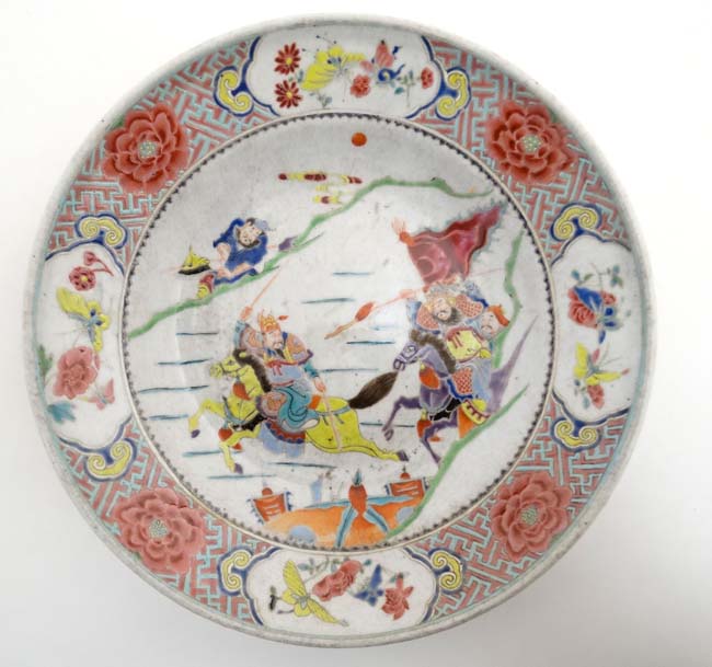 A Chinese bowl decorated in polychrome enamels with warring figures on horse back to well ,