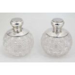 A pair of large cut glass scent bottle with silver tops.