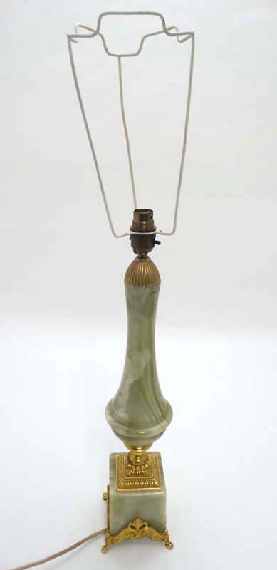 An Onyx and gilt table lamp of shaped form on a squared base.
