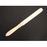 An early 19thC carved ivory page turner with reeded handle.