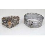 A white metal bracelet with filigree decoration together with a silverplate bangle of belt form