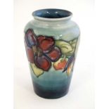 A mid 20thC Moorcroft '' Clematis '' pattern vase on a pale blue ground with tube lined decoration,