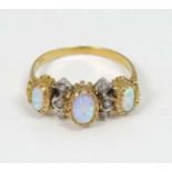 A silver gilt ring set with three graduated opal like cabochon an 6 white stones.