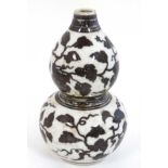 Chinese brown and white double gourd vase , decorated with fruiting vines and decorative bands.