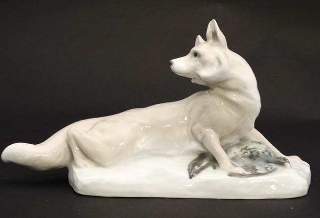 A figurine modelled as a fox with duck at its feet,