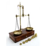 An early 19thC set of jewelllers travelling balance scales weighing 5oz of brass and mahogany