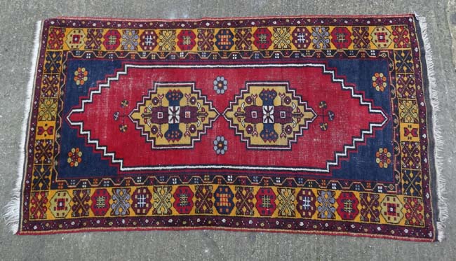 Rug / Carpet : A hand made woollen rug with blue ground, double medallion to centre and yellow ,
