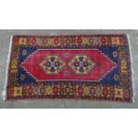 Rug / Carpet : A hand made woollen rug with blue ground, double medallion to centre and yellow ,