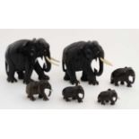 A collection 6 graduated ebony elephants with bone eyes,