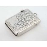 A Victorian silver vesta case with engraved decoration, hinged lid and striker under.