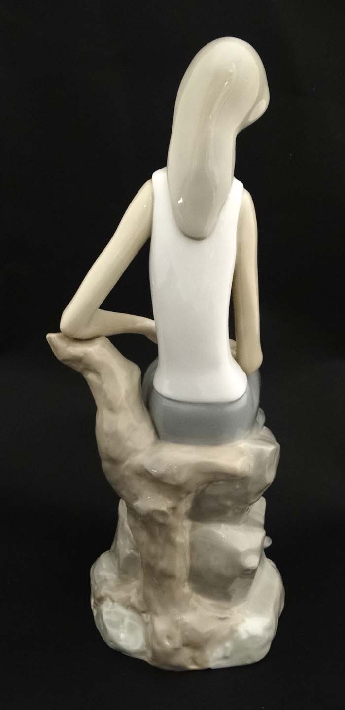 A Lladro figure modelled as a lady sat upon a rock, bears factory stamp to base. - Image 2 of 4