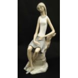 A Lladro figure modelled as a lady sat upon a rock, bears factory stamp to base.