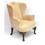An 18thC Geo II wing back upholstered armchair on walnut legs 40" high CONDITION: