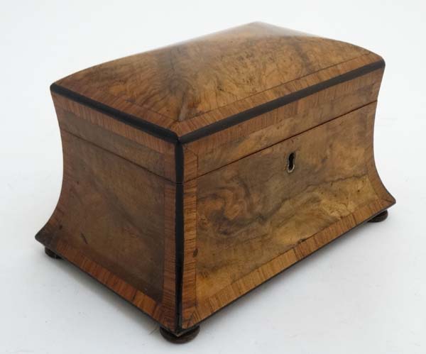 A Victorian burr walnut cross banded concave 2 division tea caddy on squat bun feet.