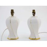 Light : a pair of late 20thC ceramic table lamps with white and gilt livery ,